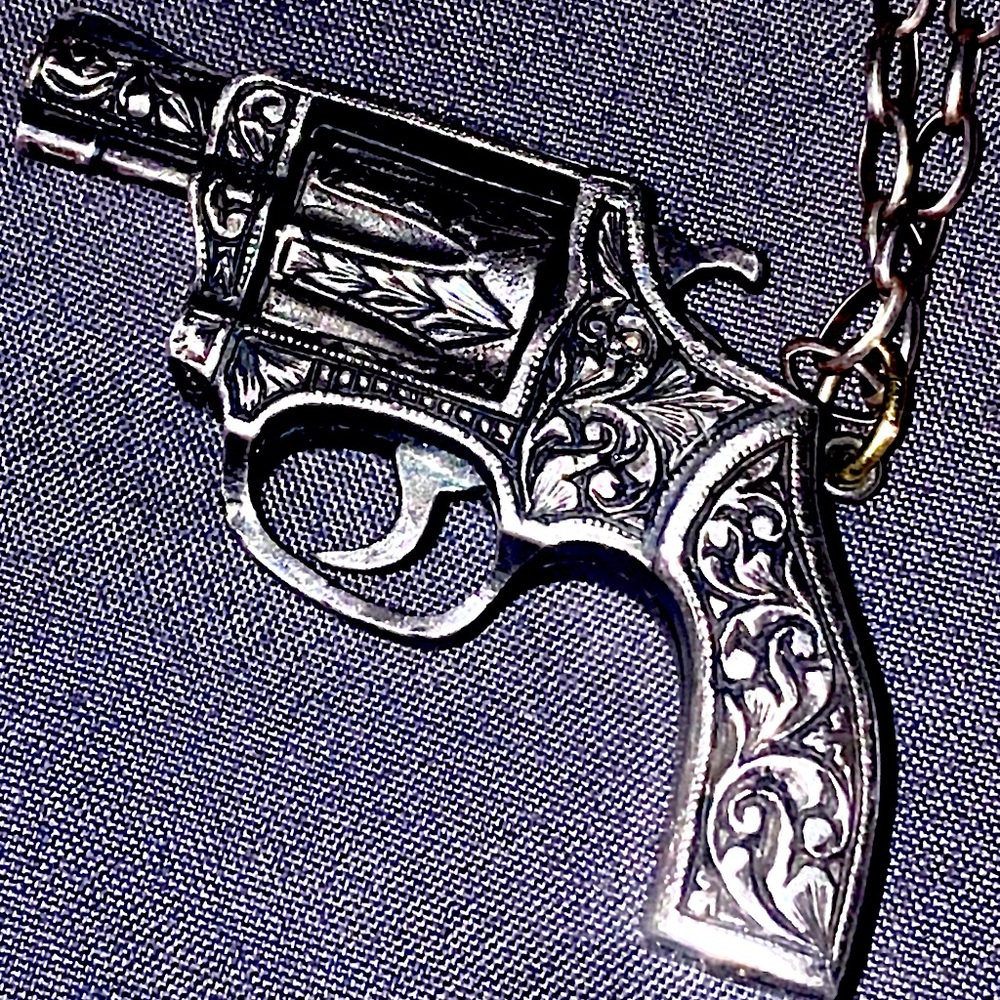 Real sterling silver, engraved revolver necklace.